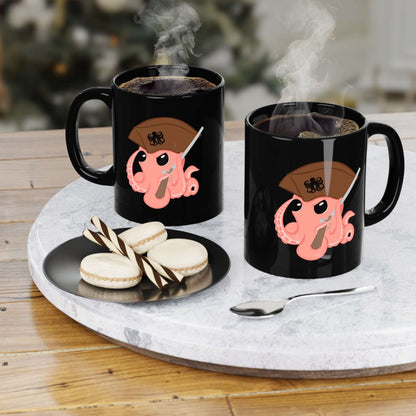 Two black mugs featuring an octopus mascot design, filled with steaming beverages, on a wooden table with cookies.